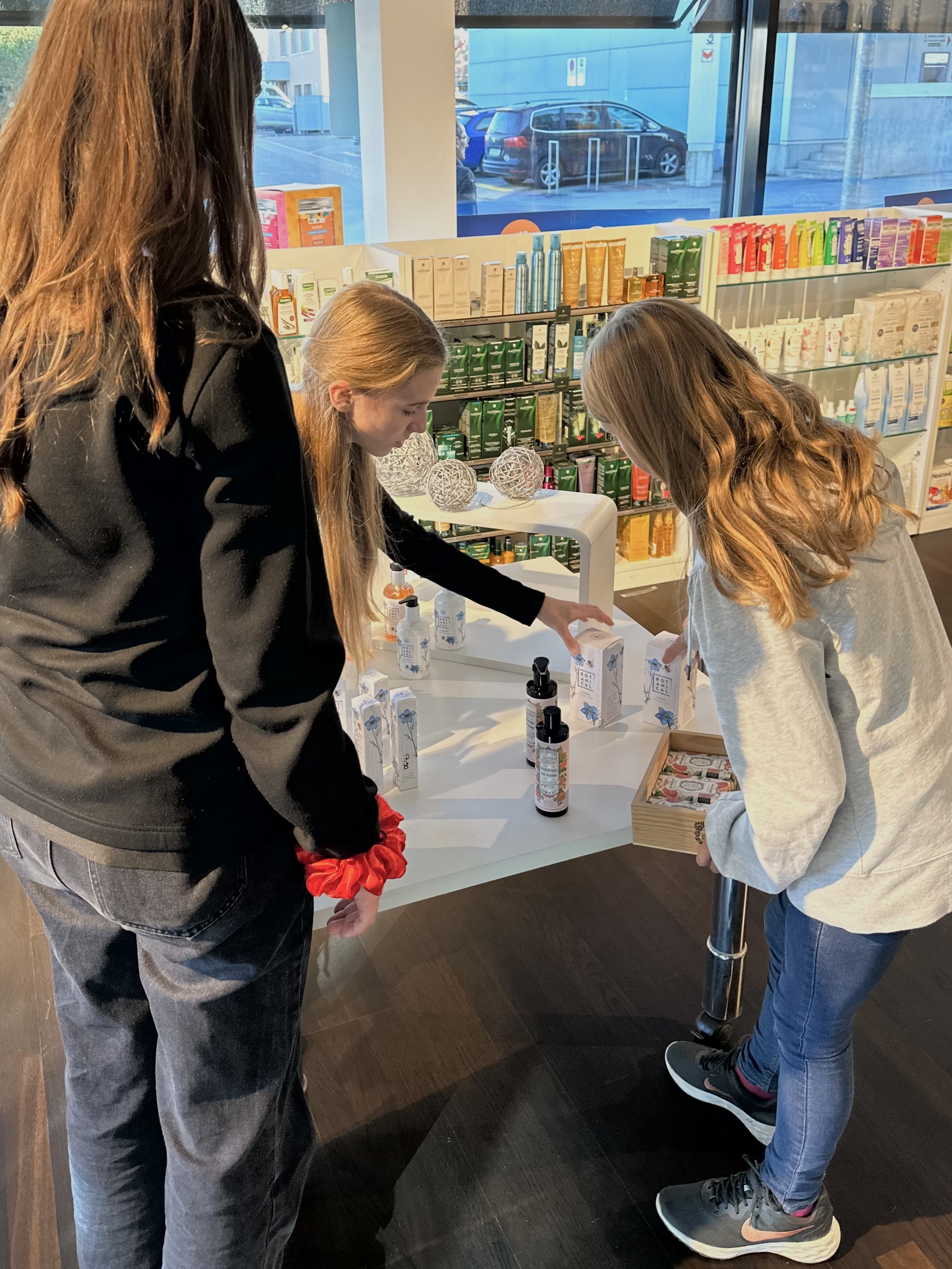 Gemeinsam diskutieren die Schülerinnen, wie die Produkte aus der Apotheke präsentiert werden sollen.